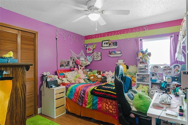 bedroom with a textured ceiling, a closet, ceiling fan, and hardwood / wood-style flooring