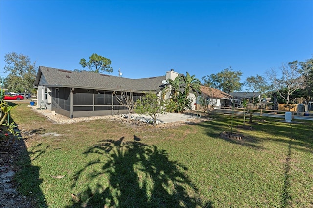 rear view of property with a sunroom and a lawn