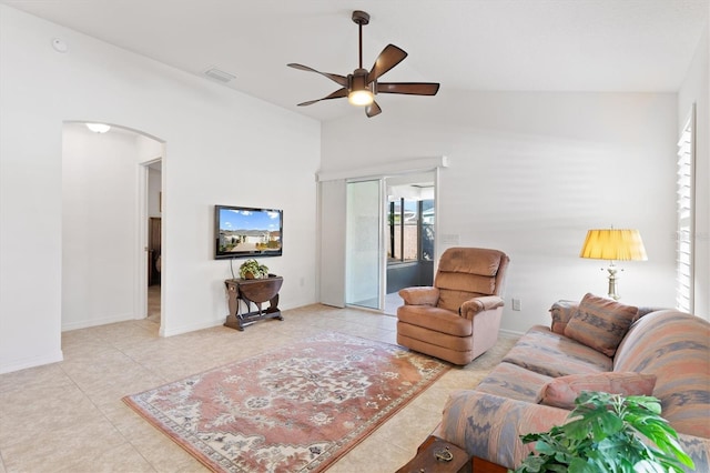 tiled living room with ceiling fan and vaulted ceiling