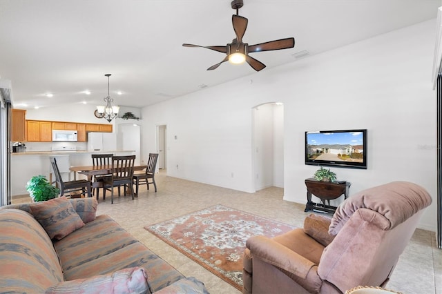 living room with ceiling fan with notable chandelier and vaulted ceiling