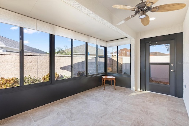 unfurnished sunroom with ceiling fan