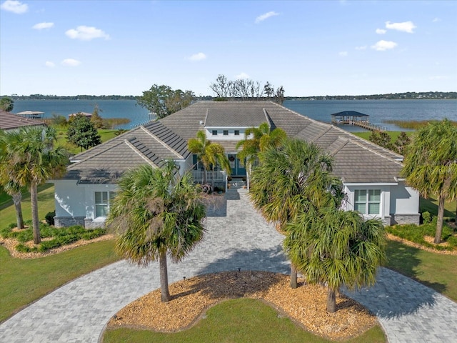 view of front of property featuring a water view and a front lawn