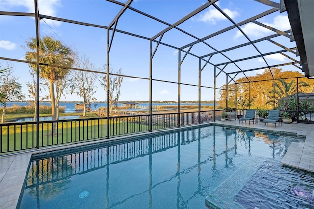 view of swimming pool featuring a lawn, glass enclosure, a water view, and a patio