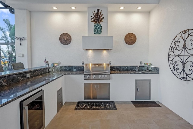 interior space with dark stone counters, sink, and beverage cooler