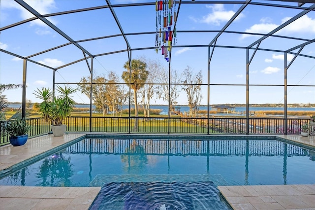 view of swimming pool featuring a patio, a water view, and glass enclosure