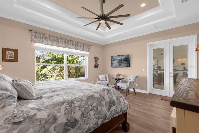 bedroom featuring hardwood / wood-style floors, a tray ceiling, ceiling fan, and crown molding