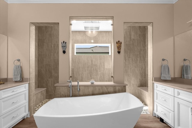 bathroom featuring wood-type flooring, vanity, and a tub to relax in