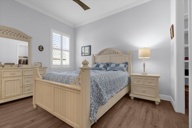 bedroom with ceiling fan, dark hardwood / wood-style floors, and crown molding