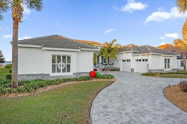 ranch-style house featuring a garage and a front lawn