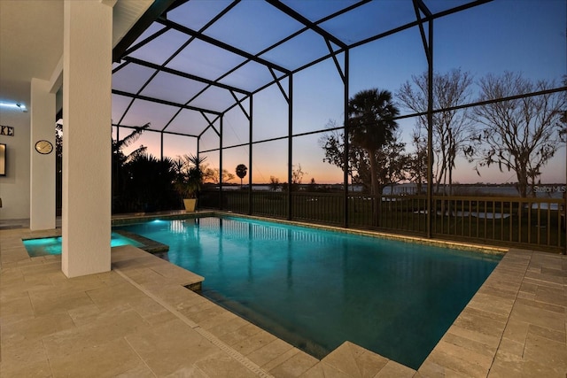 pool at dusk with a patio area and a lanai