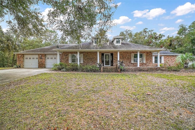 view of front of property featuring covered porch, a garage, and a front lawn