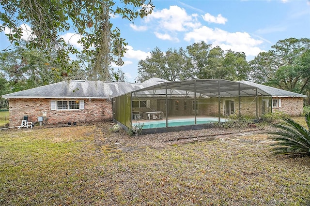 back of property featuring a lawn and glass enclosure