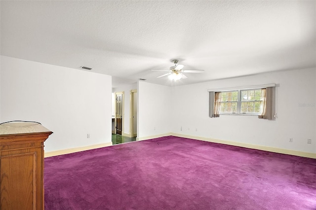 carpeted empty room with ceiling fan and a textured ceiling