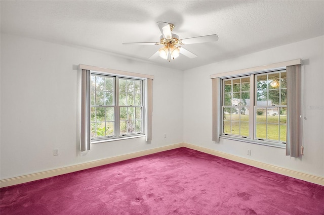 carpeted spare room featuring ceiling fan and a textured ceiling