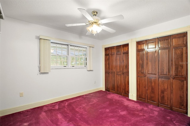 unfurnished bedroom featuring carpet flooring, two closets, and ceiling fan