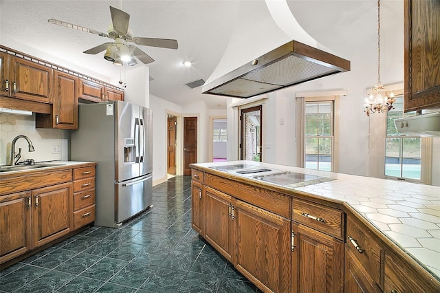 kitchen featuring ceiling fan with notable chandelier, vaulted ceiling, sink, stainless steel fridge with ice dispenser, and white electric cooktop