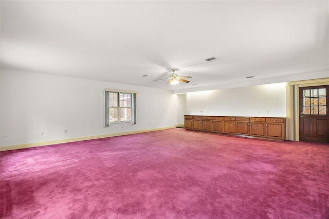 carpeted empty room with plenty of natural light and ceiling fan