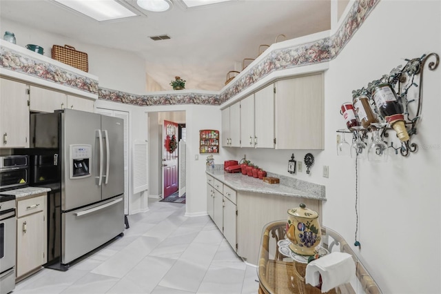 kitchen featuring lofted ceiling, stainless steel appliances, and light tile patterned floors