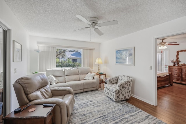 living room with hardwood / wood-style floors, a textured ceiling, and ceiling fan