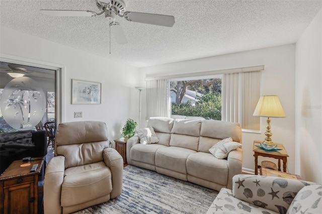 living room with a textured ceiling and ceiling fan