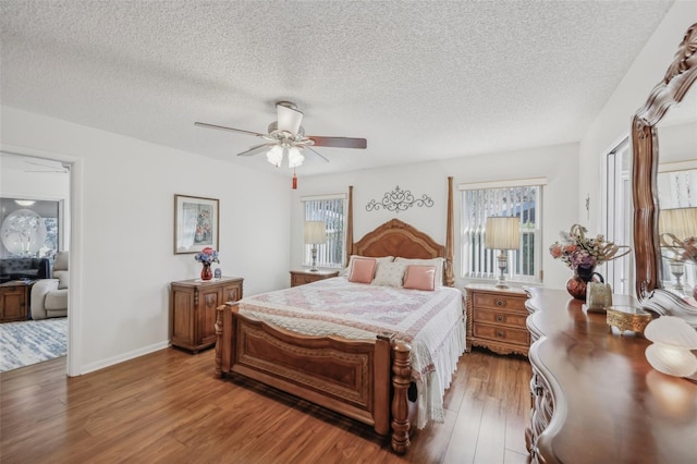 bedroom featuring ceiling fan, wood-type flooring, and a textured ceiling