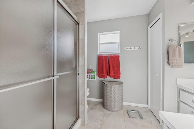 bathroom with tile patterned flooring, vanity, toilet, and an enclosed shower