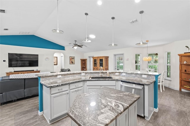 kitchen with white cabinetry, an island with sink, ceiling fan, hanging light fixtures, and stainless steel dishwasher