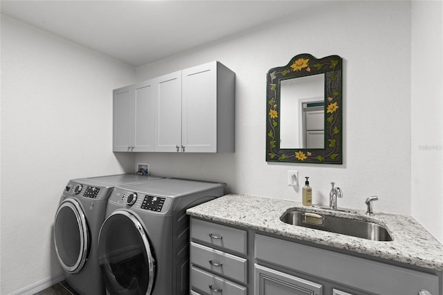 washroom with sink, washing machine and clothes dryer, and cabinets