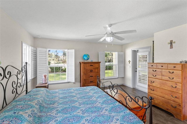 bedroom featuring a textured ceiling, ceiling fan, dark hardwood / wood-style floors, and multiple windows