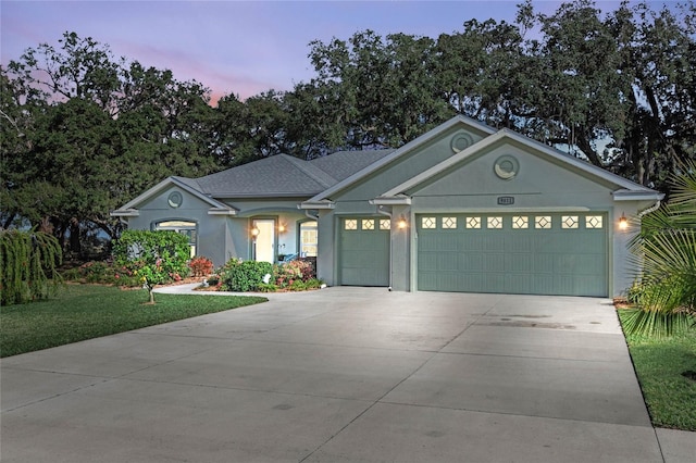 view of front of house featuring a garage and a lawn