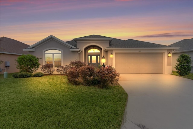 prairie-style home with a garage and a lawn