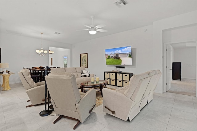 living room with light tile patterned floors and ceiling fan with notable chandelier