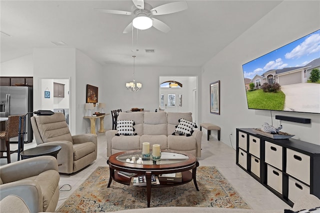 living room with light tile patterned floors, ceiling fan with notable chandelier, and washer / dryer