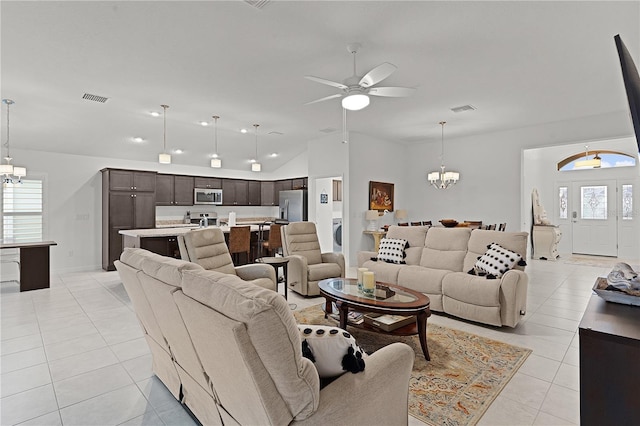 living room with ceiling fan with notable chandelier, light tile patterned flooring, and vaulted ceiling