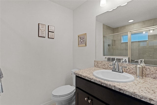 bathroom featuring vanity, toilet, and walk in shower