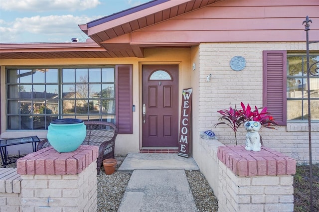 view of exterior entry with brick siding