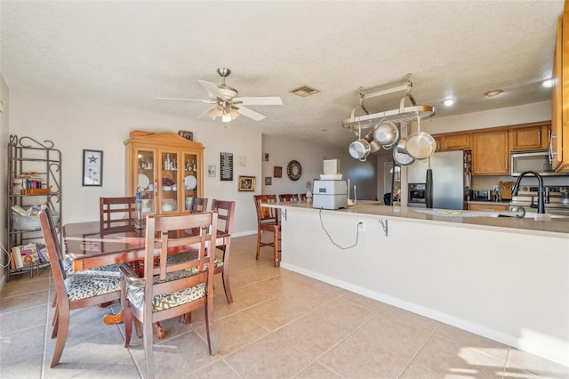 dining room featuring a ceiling fan, visible vents, a textured ceiling, and light tile patterned flooring