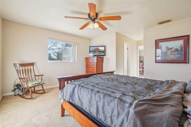 bedroom with baseboards, visible vents, a textured ceiling, and light colored carpet