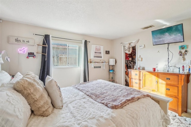 bedroom with a textured ceiling and visible vents