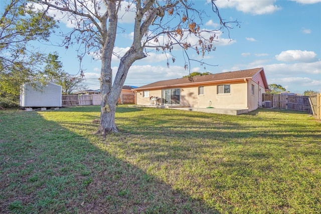 view of yard with central AC, a storage unit, an outdoor structure, and a fenced backyard