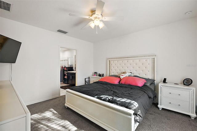 bedroom featuring ceiling fan, dark carpet, and ensuite bath