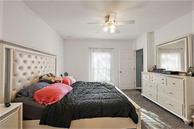 bedroom with ceiling fan and dark colored carpet