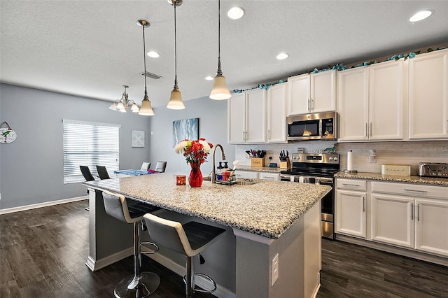 kitchen featuring appliances with stainless steel finishes, sink, a center island with sink, and white cabinets