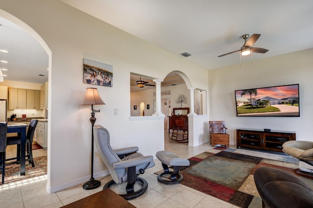 tiled living room with ornate columns and ceiling fan