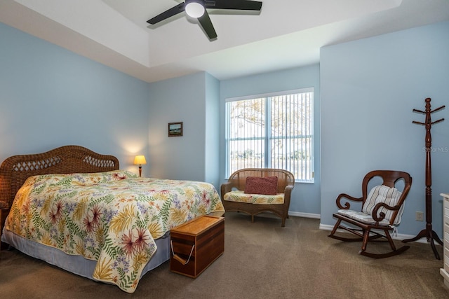 carpeted bedroom featuring a tray ceiling and ceiling fan