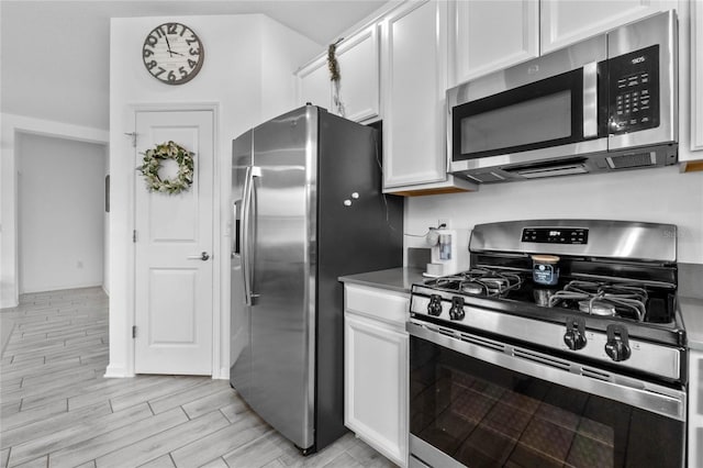 kitchen featuring white cabinets, stainless steel appliances, and light wood-type flooring