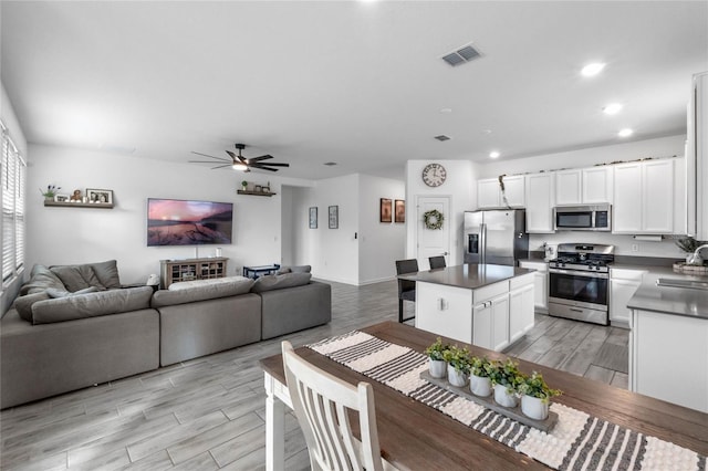 kitchen featuring a center island, sink, light wood-type flooring, white cabinetry, and stainless steel appliances