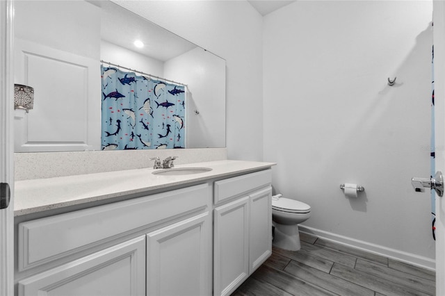 bathroom featuring hardwood / wood-style floors, vanity, a shower with shower curtain, and toilet