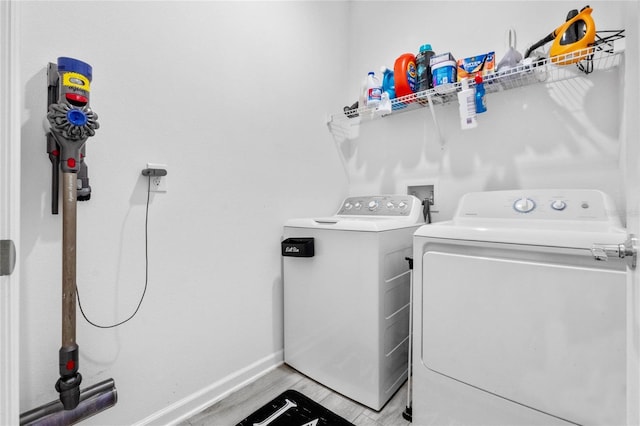 laundry area with light hardwood / wood-style flooring and washer and dryer