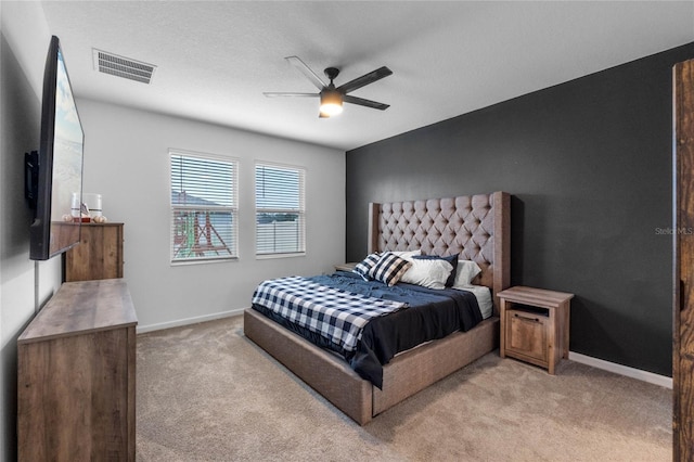 carpeted bedroom featuring a textured ceiling and ceiling fan